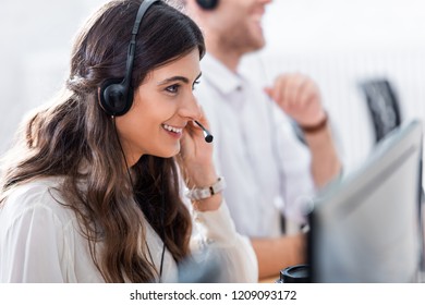 selective focus of smiling female call center operator in office - Shutterstock ID 1209093172