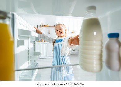 Selective Focus Of Smiling Kid Taking Bottle With Milk From Fridge