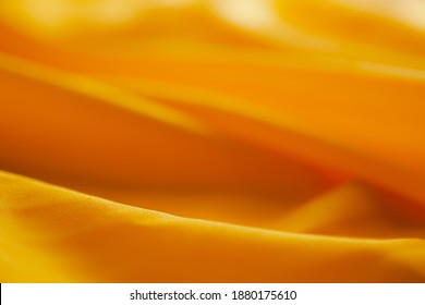 Selective focus soft yello satin fabric for background  luxurious 
wallpaper cloth  blur copy space you add text for presentation 
work holidays summer 