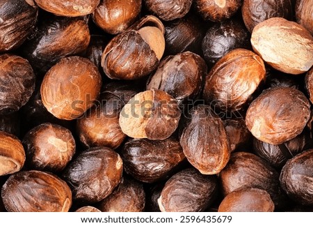 selective focus. some Nutmeg or Jaiphal is an aromatic spice. Also Known as Myristica Fragrans. Closeup of Organic nutmeg seed. (Javitri). Indian Aromatic Spice. Top view. food background