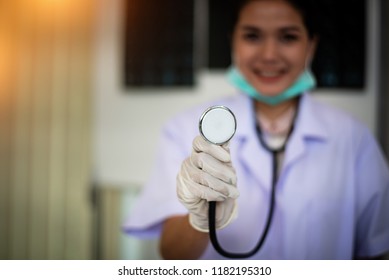 In Selective Focus Of The Stethoscope In Doctor Hand,warm Light Tone,blurry Light Design Background