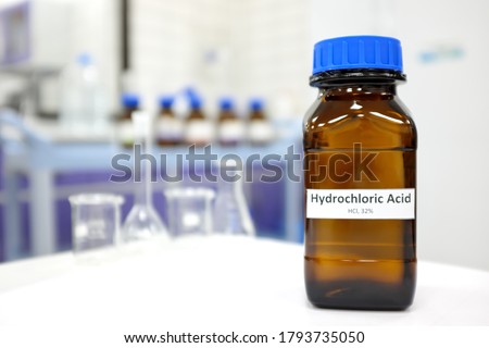 Selective focus of strong Hydrochloric acid solution in brown amber bottle. Blur laboratory backdrop with copy space.