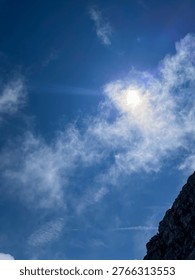 selective focus sun shining through clouds over mountain peak