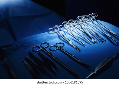 selective focus surgical instrument lying on table while group of surgeon work in operation room at hospital, emergency case, surgery, medical technology, health care cancer, disease treatment concept