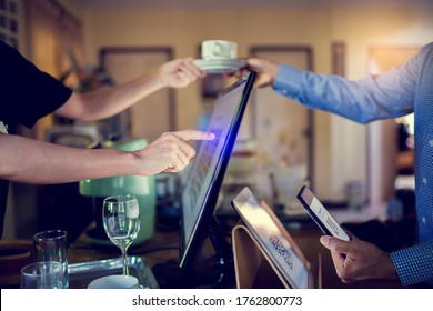 Selective Focus To Tablet And Blurry Customer Using Smart Phone Scan QR Code On Tablet To Payment With Cashier Machine At Counter Bar In Coffee Shop. Accepted Generate Digital Pay Without Money.