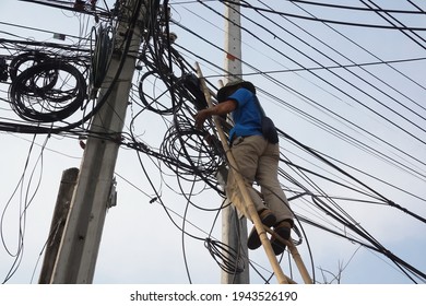 Selective focus technician man stands on ladder without safety belt is risk work while fixing fiber optical cable. Unsafe workplace, risk work, unsafe acts concept.                                