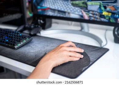 Selective Focus Of A Teenager Hand Playing On A Gaming Computer, With A Black Keyboard On A Large Gray Mouse Pad, Online Network Games, Addition To Video Games, Horizontal