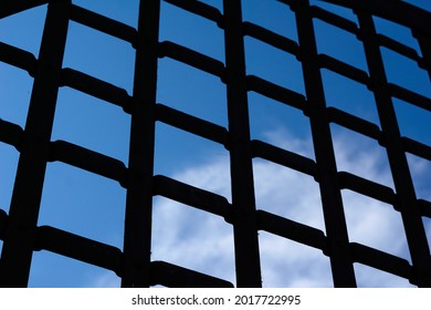 Selective focus, texture of a metal old lattice fence against the blue sky, fence lattice, lattice background, cell. High quality photo