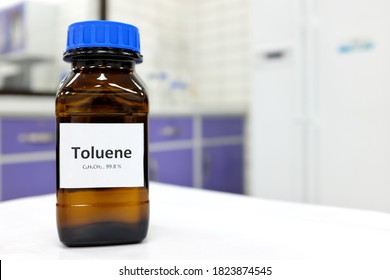 Selective focus of toluene liquid chemical compound in dark glass bottle inside a chemistry laboratory with copy space. Aromatic hydrocarbon used in petrochemical industry.