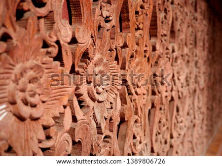 Selective focus of traditional flower pattern on the antique Thai style wooden fence wall craving, art and culpture concept