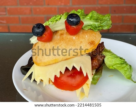 Selective focus view Halloween Monster Burgers or sandwiches, egg mayo, on white ceramic plate. Halloween food concept, celebration party, Vegan Food. Kid party food