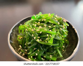 Selective focus view of Japanese Seaweed Salad (Wakame) with black background. It is a flavorful and delicious Japanese-style salad made with dried seaweed that has been reconstituted. - Shutterstock ID 2217718157