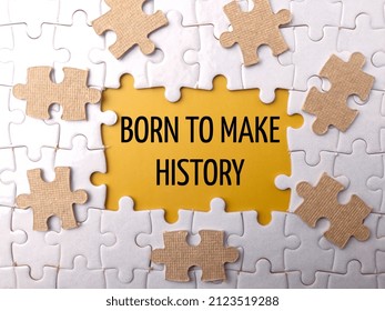 Selective focus.Top view jigsaw puzzle with text BORN TO MAKE HISTORY on a yellow background.