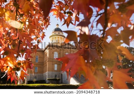 Selective focus view of liquid amber leaves framing the historic courthouse of Auburn, California, USA.