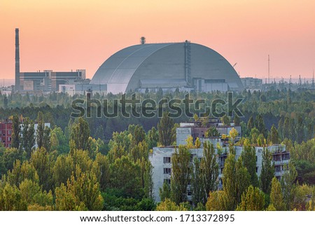 Selective focus, view of the new safe confinement arch at sunrise above Chernobyl nuclear power plant through the prospect of abandoned Pripyat. NSF is a new sarcophagus for safe deactivation work