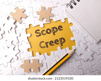 Selective focus.Top view pencil and notebook with text Scope Creep on a white puzzle background. - Shutterstock ID 2123519330