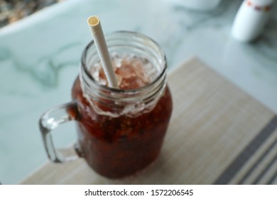 Selective focus of white paper straw on a ice coffee glass. Paper straw is good for environment more than plastic straw. Object, drink, and environment concept.