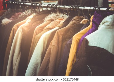 Selective focus winter coats hanged on a clothes rack.