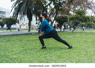 Selective Focus Of Woman Exercising And Warming Up With Face Mask. New Normal