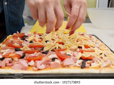 selective focus. woman sprinkles pizza with grated cheese. homemade pizza cooking concept. - Powered by Shutterstock