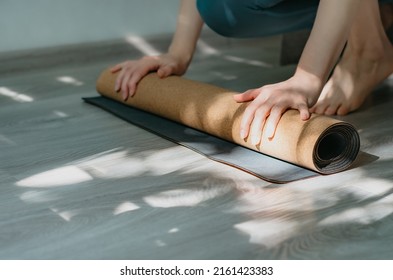 Selective focus of woman unrolling cork yoga mat to practice yoga. Concept: self care routine practices at home	 - Powered by Shutterstock