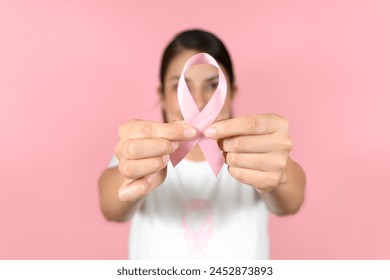 Selective focus of woman's hands holding a pink ribbon. breast cancer awareness concept - Powered by Shutterstock