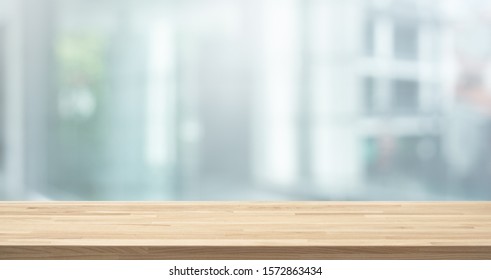 Selective focus of wood table top on white wall glass (big window) background.For montage product display or design key visual layout
