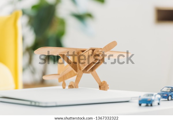 selective focus of wooden plane model and miniature car\
models 