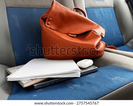 selective focus work backpack with notebooks and gadgets ready on car seat