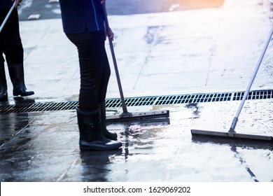 Selective focus to worker using wiper or squeegee to clean floor surface. Staff cleaning floor with wiper. The concept of cleaning service. - Powered by Shutterstock