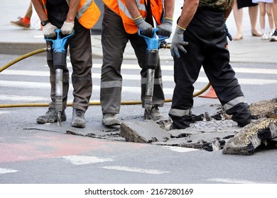 Selective Focus To Workers Repair The Road Surface With A Jackhammers. Construction Work, Sewer Repairing In City