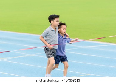 Selective Focus At Young Asian Boy Carry Each Other To Finished Line.