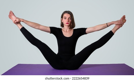 Selective focus. Young female contortionist. Beautiful woman contorting her body. Young woman in yoga pose. Young female gymnast.