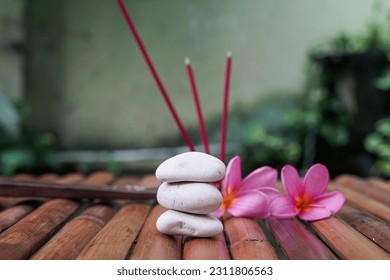 selective focus zen stone on bamboo table with frangipani flower and incense stick - Shutterstock ID 2311806563