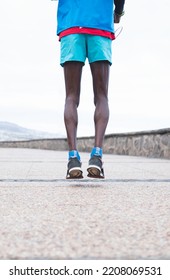 Selective Focus.Black Male Athlete Dressed In Sportswear, Running On Promenade By The Sea.