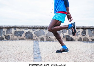Selective Focus.Black Male Athlete Dressed In Sportswear, Running On Promenade By The Sea.