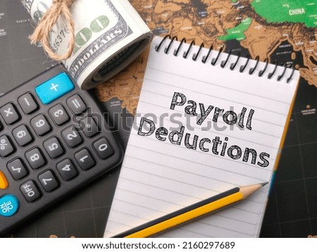 Selective focus.Calculator,pencil and banknotes with the word Payroll Deduction on world map background.