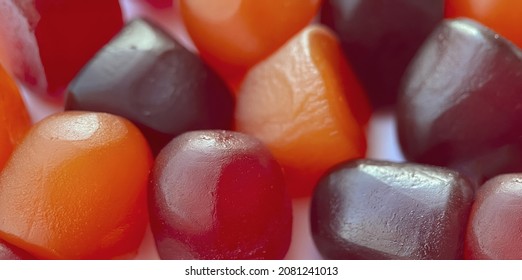 Selective Focus.Close-up Texture Of Red, Orange And Purple Multivitamin Gummies On White Background