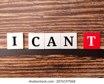 Selective focus.Colored cube with text I CAN T on a wooden background.
