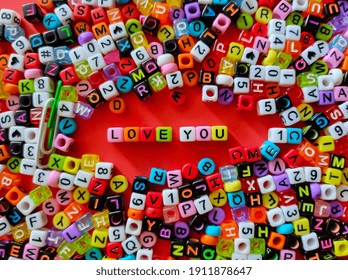 Selective focus.Colorful dice with word LOVE YOU on a red background.Valentine days concept.Shot were noise and film grain.
