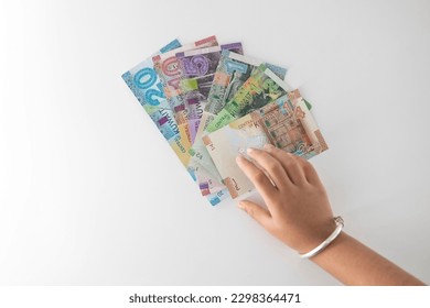 Selective focused , Full set of Kuwaiti Dinar bank paper notes. Kuwait dinar bank notes 0.25KWD, 0.5KWD, 1KWD, 5KWD, 10 KWD and 20 KWD. Kid trying to take the Kuwait dinar bank notes