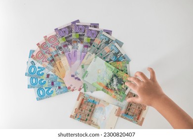 Selective focused , Full set of Kuwaiti Dinar bank paper notes. Kuwait dinar bank notes 0.25KWD, 0.5KWD, 1KWD, 5KWD, 10 KWD and 20 KWD. Kid trying to take the Kuwait dinar bank notes