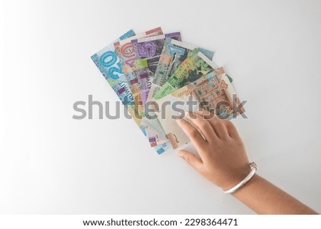 Selective focused , Full set of Kuwaiti Dinar bank paper notes. Kuwait dinar bank notes 0.25KWD, 0.5KWD, 1KWD, 5KWD, 10 KWD and 20 KWD. Kid trying to take the Kuwait dinar bank notes