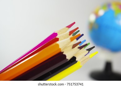 Selective focused mainly on colored pencils isolated on white background. Used with related objects (selective focused or out of focused) with educational concept purposes.