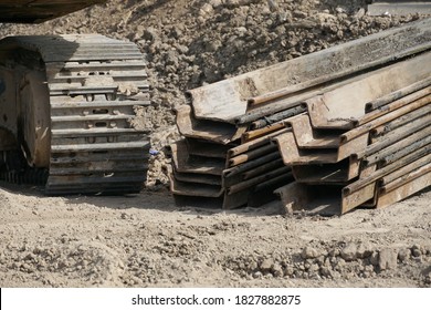 Selective Focused, Steel Sheet Piles On Ground At Construction Site, Crawler Excavator Background. Concept Of Sheet Pile, Construction Site.