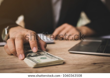 Selective focus,Man offering batch of hundred dollar bills. Hands close up. Venality, bribe, corruption concept. Hand giving money - United States Dollars (or USD),filter color effect.
