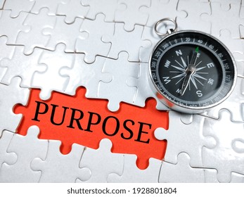 Selective focus.Word PURPOSE with compass on jigsaw puzzle and red background.Business concept. - Shutterstock ID 1928801804