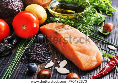 Selective of ingredients with fish and organic vegetables, cereals rich of amino acids,  oligominerals  for healthy seasonal cooking on black wooden background, top view, place for text.