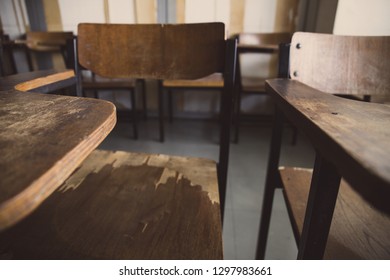 Selective Soft And Blur Focus.old Wooden Row Lecture Chairs In Dirty Classroom In Poor School.study Room Without Student.concept For Education In Third World ,donate And Charity,background Text