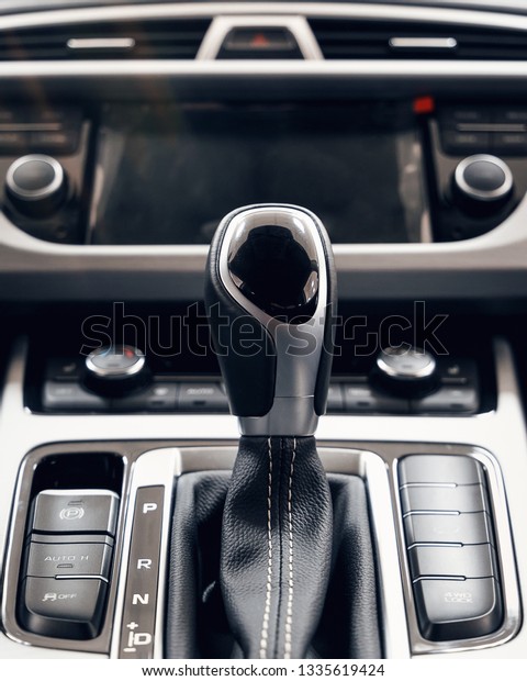 Selector\
automatic transmission with perforated leather in the interior of a\
modern expensive car. The background is\
blurred